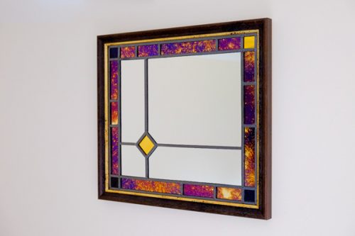 Framed stained glass mirror in purple and gold